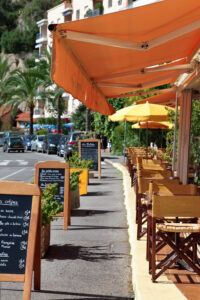 Typical French restaurant scene of tables and chairs and menu board